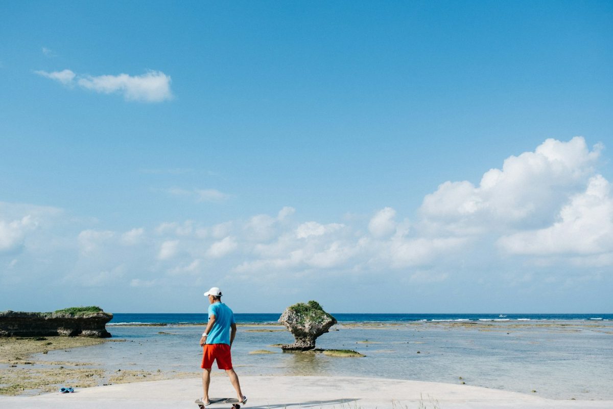 Older man walking along a tropical shoreline
