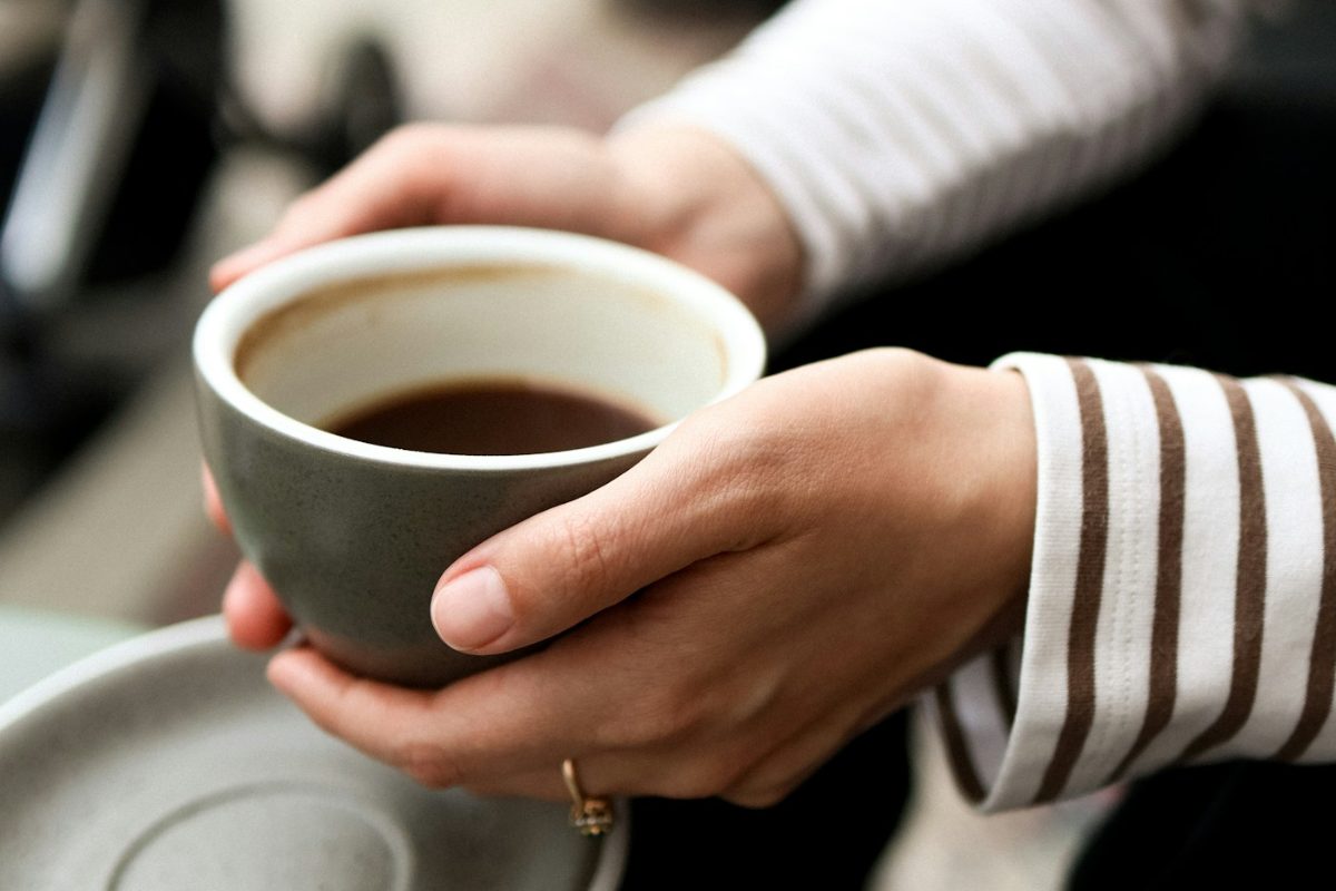 Hands wrapped around a warm cup